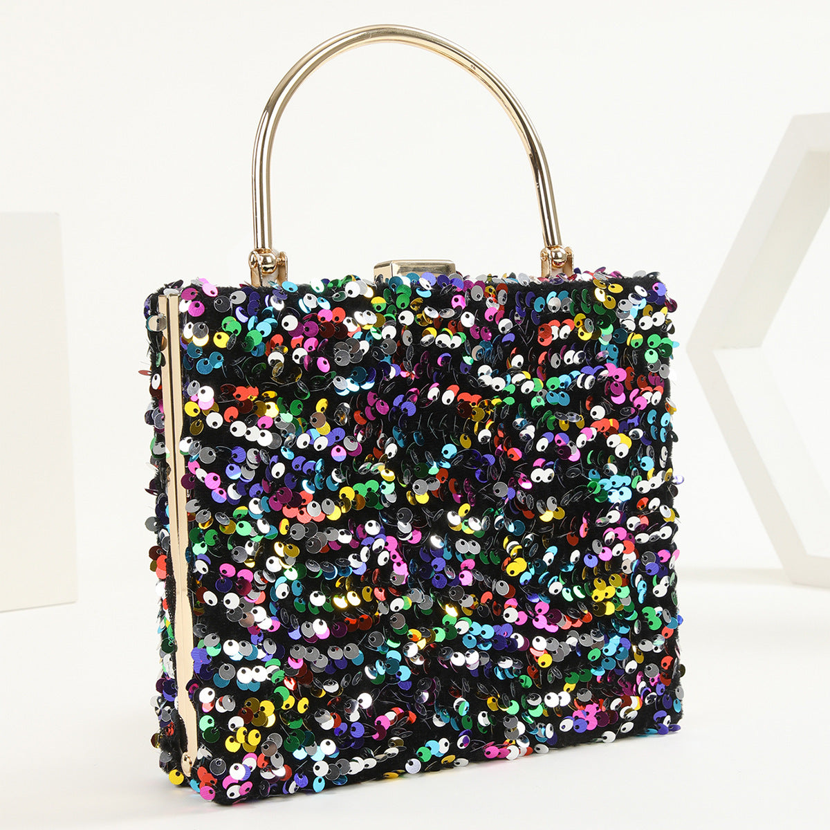 womens hand holding dinner bag colorful sequins