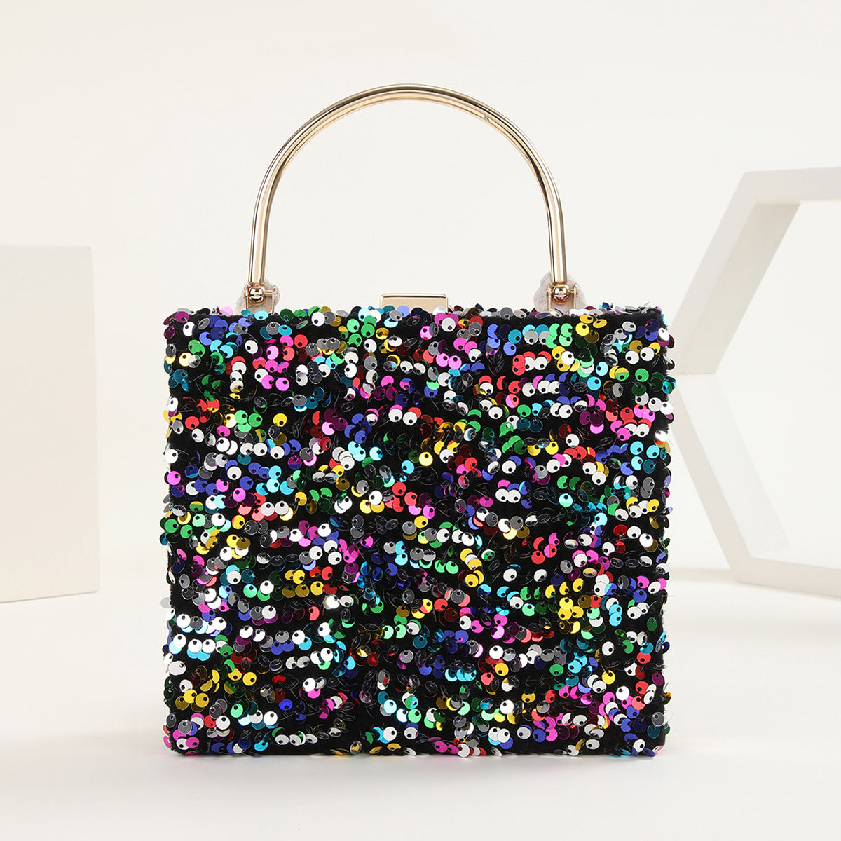 womens hand holding dinner bag colorful sequins