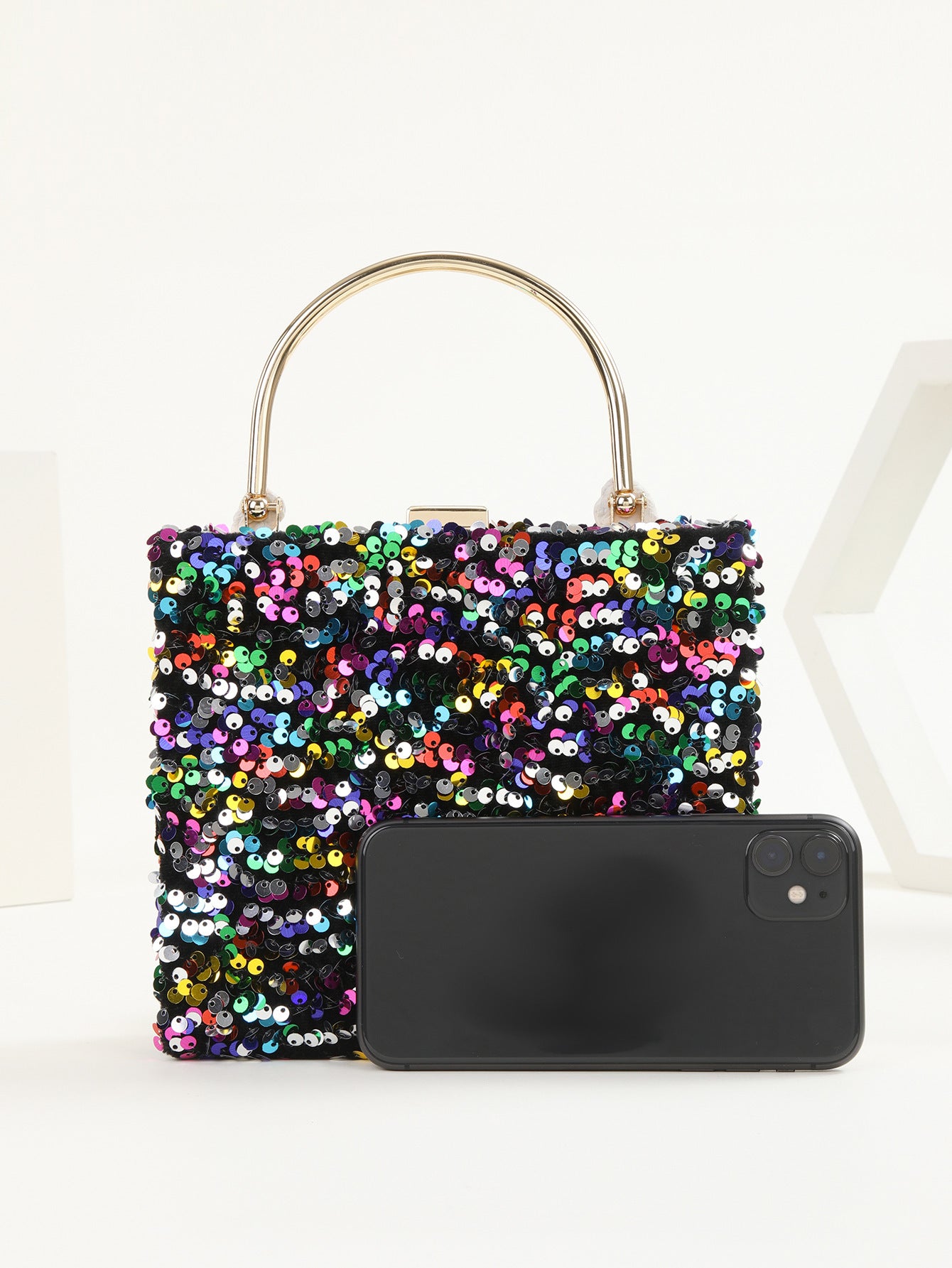 womens hand holding dinner bag colorful sequins