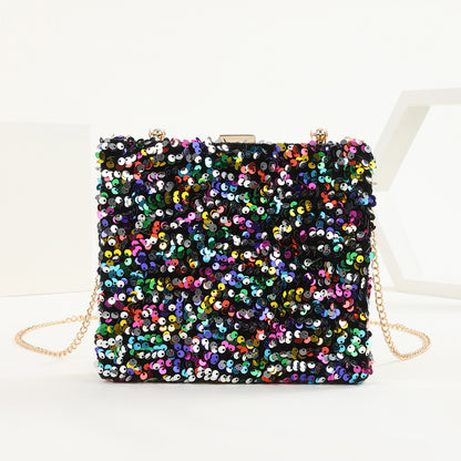 womens hand holding dinner bag colorful sequins